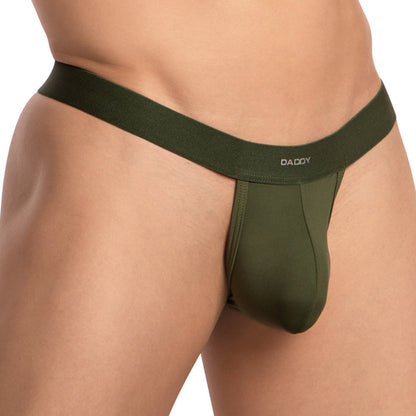 Close-up of a person wearing Daddys Strapped T-Back G-string in green with a black waistband and DADDY boldly printed. This design enhances the waist and hips, exuding confidence and allure with its daring style.