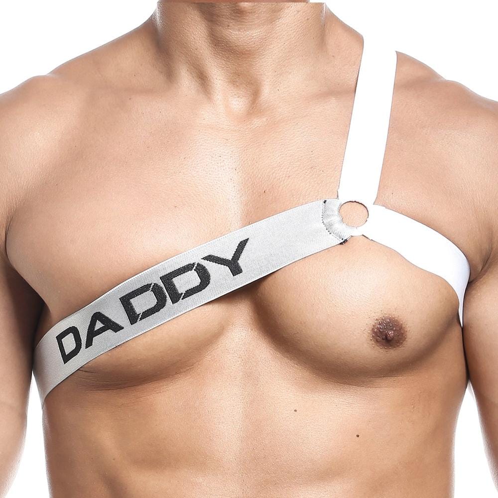 A person is wearing the Daddy Harney Man Strap, a sexy mens top with a white three-strap design across the torso. DADDY is boldly printed on one strap, and an edgy circular metal ring adorns near the shoulder.