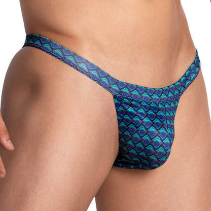 Close-up of a person wearing Daniel Alexander Mens Wave Bikini, showcasing its blue and green wave print with geometric, fish-scale patterns. The side view highlights the comfortable elastic waistband.