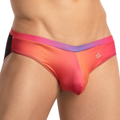A close-up features the Daniel Alexander Color Slash Bikini, showcasing a small logo and vibrant gradient colors of orange, pink, and purple with a black hip section. This seductive piece by Daniel Alexander emphasizes its design and vibrancy.