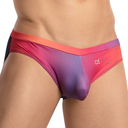 Wearing the Daniel Alexander Color Slash Bikini, a person showcases vibrant gradient-colored mens underwear transitioning from red to purple. The red waistband features a small logo, providing a perfect fit that captures vibrant seduction.