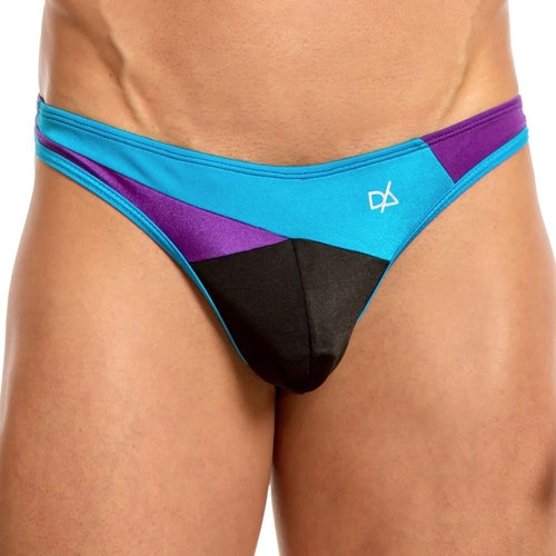 A person is wearing a Daniel Alexander Slash Thong, featuring an enhancing pouch and sleek blue, purple, and black panels with a small logo. The background is plain white.