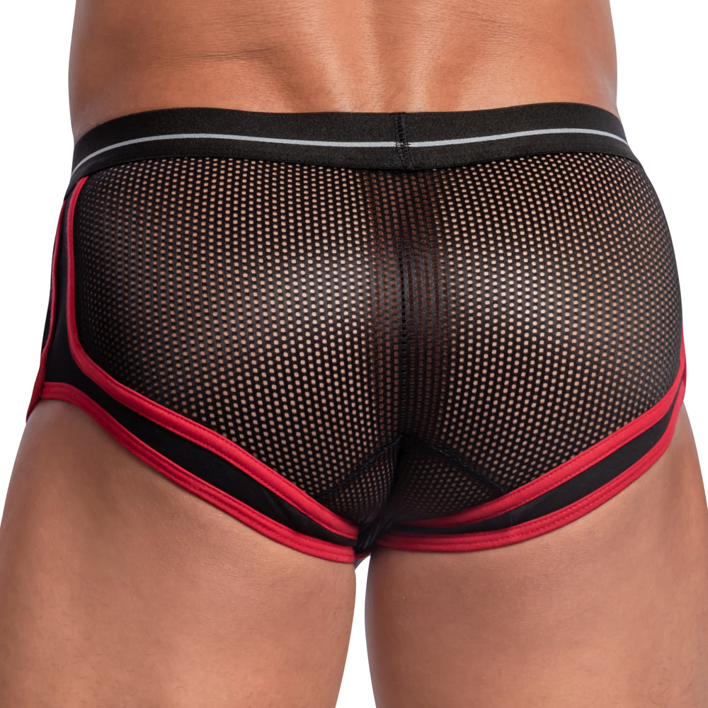The person is wearing Feels Feel Sheet Sides Boxer, featuring black mesh with red trim, a contouring pouch, sheer side panels, and a contrasting waistband. The image emphasizes the breathable fabrics texture and intricate design.
