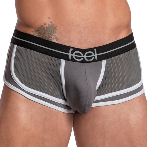 A person is wearing Feels Feel Sheet Sides Boxer featuring gray mesh with a black waistband that says feel. It includes a contouring pouch for support, sheer side panels for style, and showcases a tattoo on their left side.