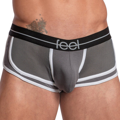 A person is wearing Feels Feel Sheet Sides Boxer featuring gray mesh with a black waistband that says feel. It includes a contouring pouch for support, sheer side panels for style, and showcases a tattoo on their left side.