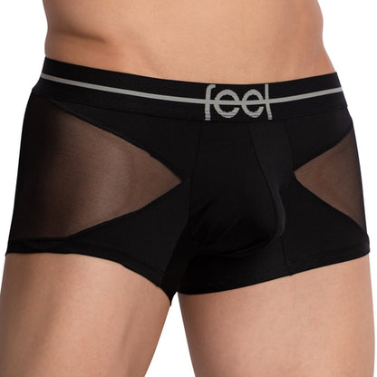 A person wearing Feels Lustrous Sports Boxer Trunk, featuring black design with sheer mesh side panels and a supportive pouch. The stretchy cotton waistband is labeled Feel, combining comfort and style effortlessly.