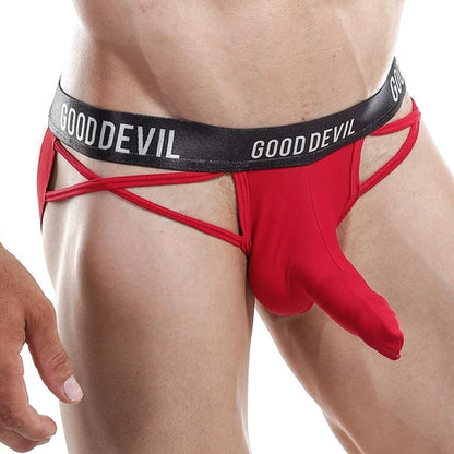 A person flaunts a red Good Devil Jockstrap with GOOD DEVIL on the waistband. With minimal coverage, it features side cut-outs and a spacious front pouch, all set against a pure white backdrop that highlights its bold design.