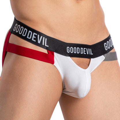 A man models the Good Devil Open Pouch Backless Jockstrap, featuring a red, white, and gray design with cut-out sides and an open pouch.