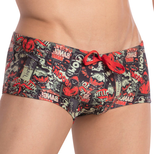 Someone is wearing Good Devil Playtime Boxer Trunk swim trunks, featuring a nostalgic print in red, black, and beige with comic book words like BOOM and BANG. The trunks provide full coverage and include a red drawstring for a secure fit.