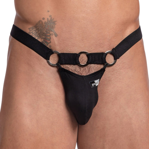 A person is wearing the Good Devil Bikinis with a steel ring waistband, featuring a minimalist black design and a branded patch on the front, complemented by an angel tattoo on the right hip.