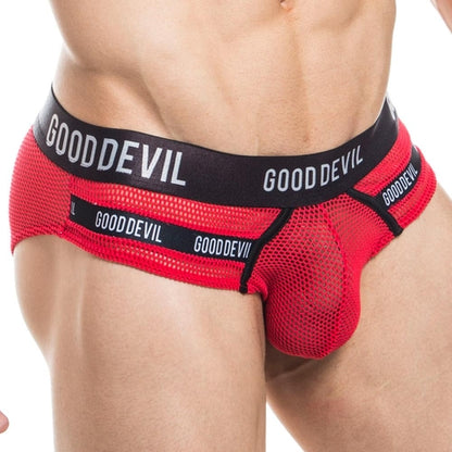 A person models the Good Devil Show It All Brief, showcasing its red mesh see-through fabric and black waistband featuring Good Devil. The form-fitting design accentuates the supportive pouch and draws attention to the midsection.