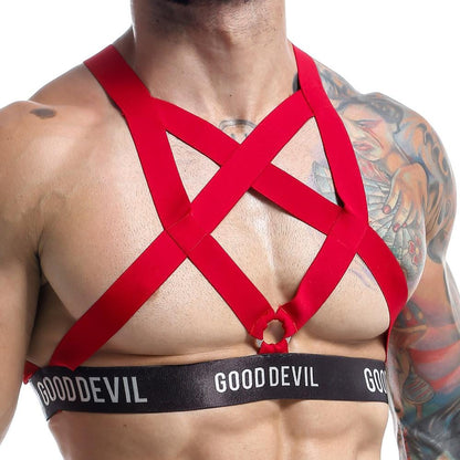 A person showcases a red crisscross harness from Good Devil Accessories over their chest, featuring a GOOD DEVIL band. Tattoos enhance their muscular frame, adding allure to the ensembles sexy back detail.