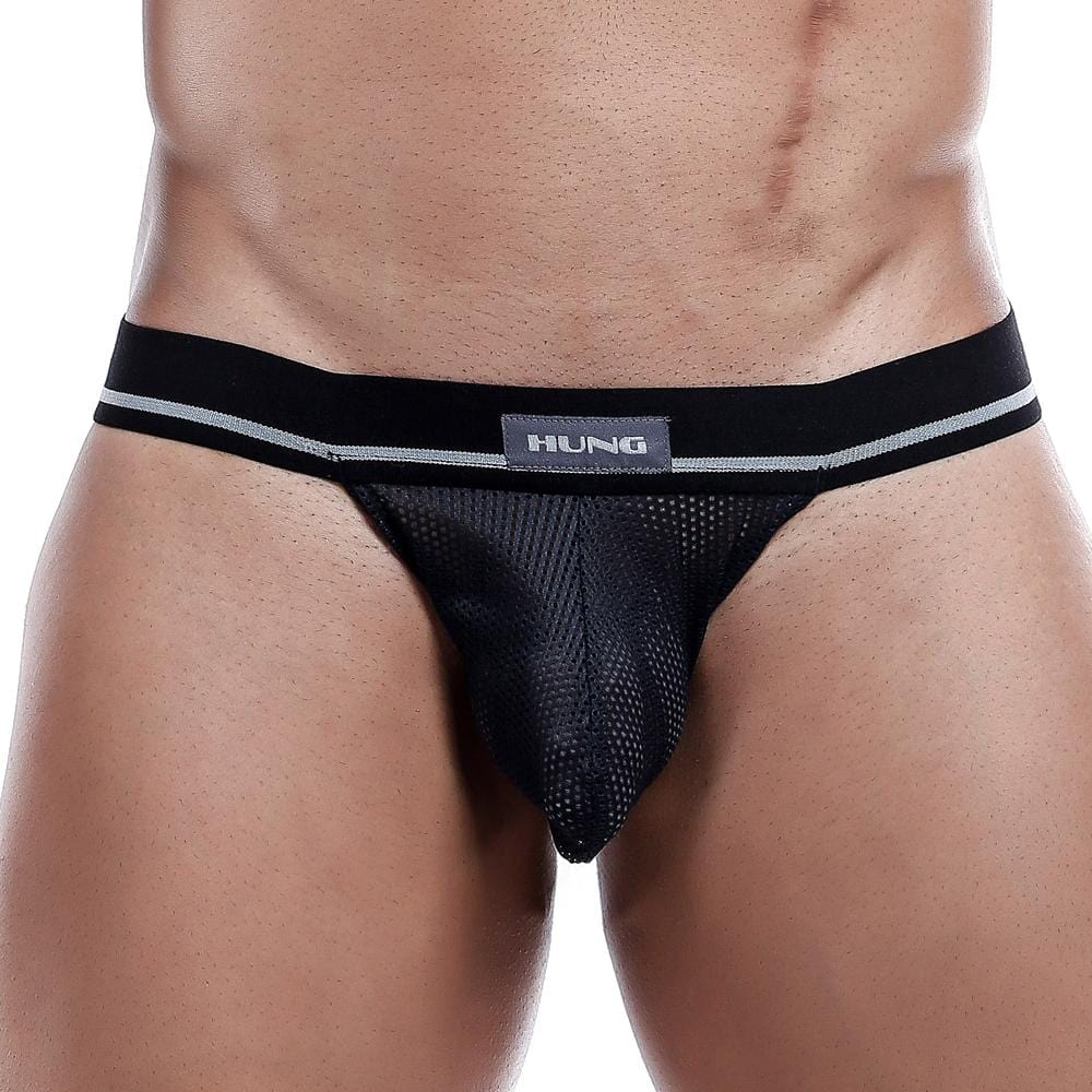 A person wearing the Hung Jockstrap, featuring a black mesh pouch, supportive straps, and a branded Hung waistband.