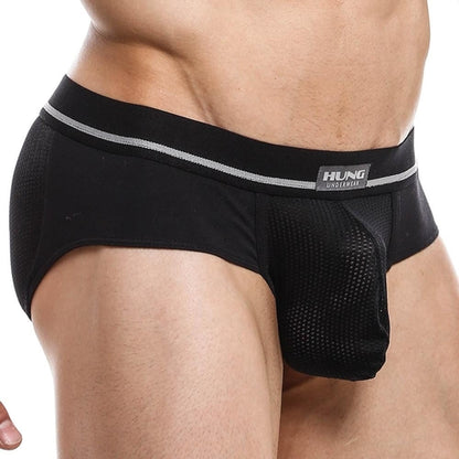 A person wears the black Hung Jockstrap, featuring a gray waistband with the HUNG logo. The textured fabric is fitted with a breathable mesh pouch, emphasizing comfort and design in mens underwear. The image highlights the lower torso.