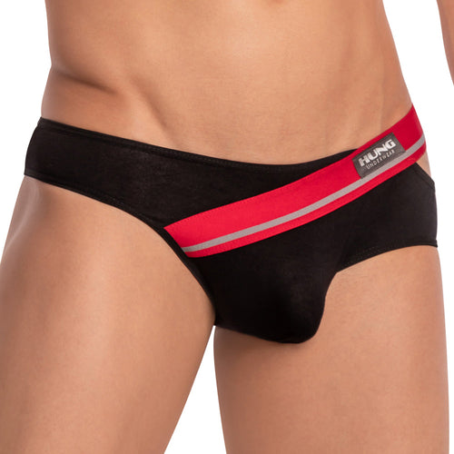 A person is modeling the Hung Ivan Brief, featuring black mens bikini briefs with a red and silver waistband. The visible Hung label highlights a snug fit and enhancing pouch, set against a plain backdrop for style and comfort.