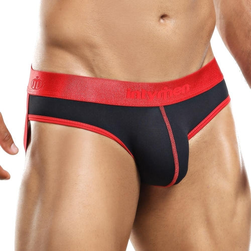 A person wearing the Intymen Jockstrap with a bold red waistband, featuring sleek design and elegant stitching for comfort and support. The plain background highlights its classic appeal from the brand Intymen.