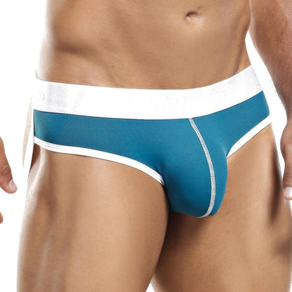 An individual sports the Intymen Jockstrap, featuring teal fabric with a white waistband and elegant stitching, highlighting its classic design. The close-up image emphasizes the vibrant color and intricate details of this Intymen creation.
