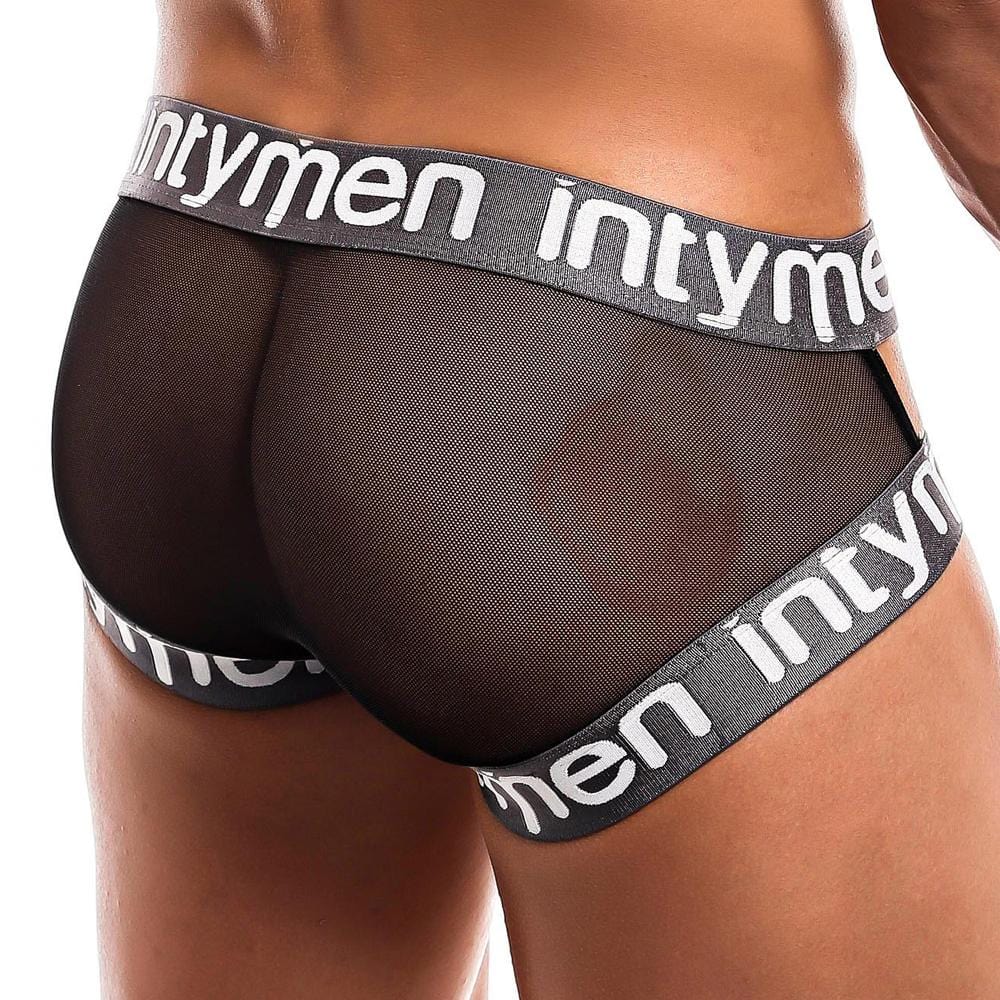 A person models black mesh Intymen Cross Jockstraps, with intymen on the waistband. This daring design has an open back and two versatile straps against a plain white background. .