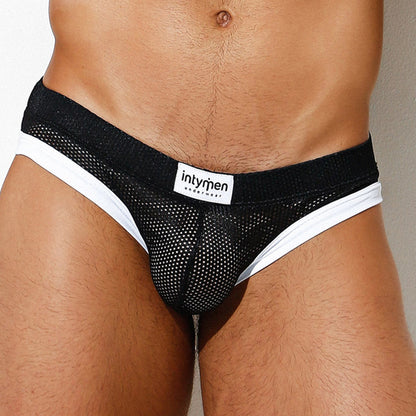 A person wearing the Intymen Dolce Jockstrap with black mesh fabric and a white waistband showcasing the visible Intymen branding. The image highlights its comfortable fit and supportive pouch, emphasizing the lower torso.