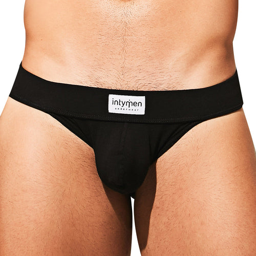 A close-up image features a person wearing an Intymen Loving Jockstrap with the brand label on the supportive waistband, crafted from a comfy cotton-spandex blend, set against a plain white background.