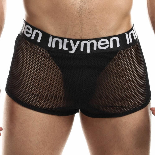 A person wearing Intymen Jock Mesh Cover boxer briefs in black with the brand name Intymen on the waistband, featuring breathable sheer mesh fabric that showcases a sporty, modern design with support.