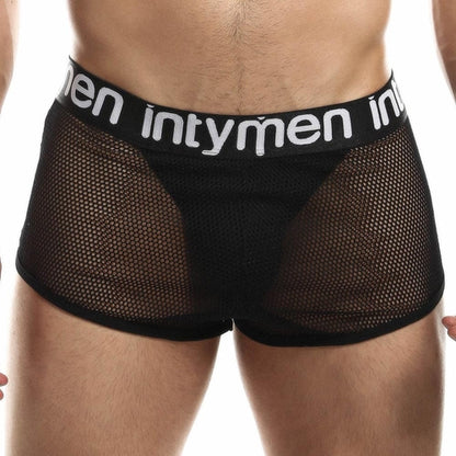 A person wearing Intymen Jock Mesh Cover boxer briefs in black with the brand name Intymen on the waistband, featuring breathable sheer mesh fabric that showcases a sporty, modern design with support.