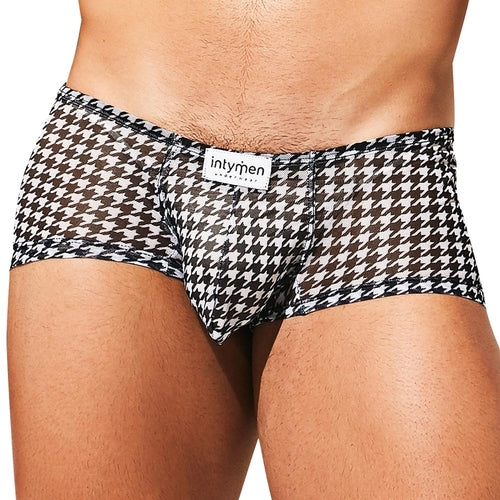 A person wearing Intymen Gales Trunk with a low-rise houndstooth-patterned mesh design and a white intymen waistband. The black and white underwear includes an enhancing pouch and sheer fabric.