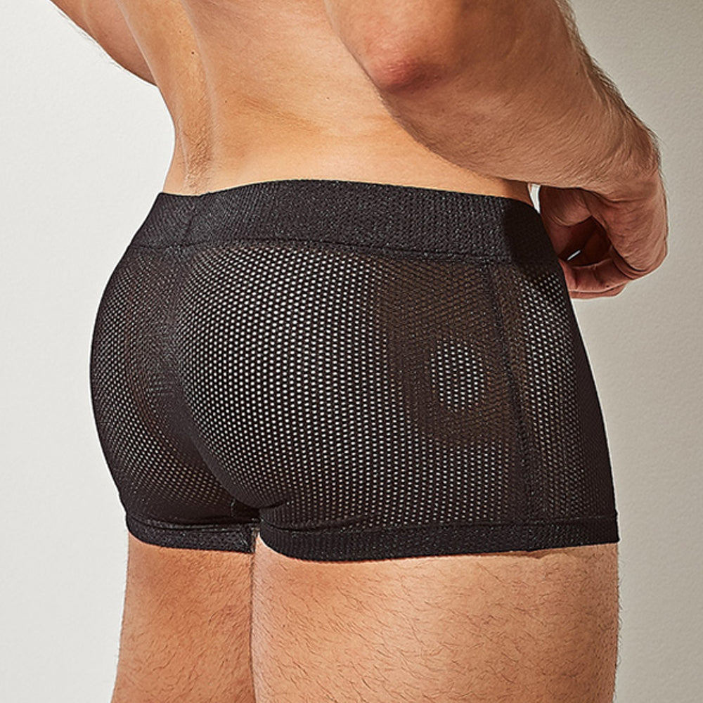 The image showcases a person from the back wearing Intymens black Bulge Pouch Athletic Boxer, highlighting its breathable mesh texture and fit. The focus is on their glowing skin at the lower back and waist area.