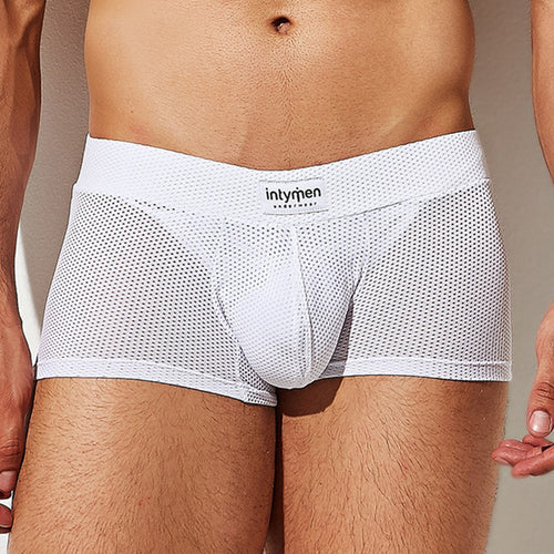 A person wearing Intymen Bulge Pouch Athletic Boxer briefs in white breathable mesh, showcasing a visible Intymen waistband. Designed for a snug fit and featuring a C-Shape Pouch for extra comfort, the focus is on the lower torso.