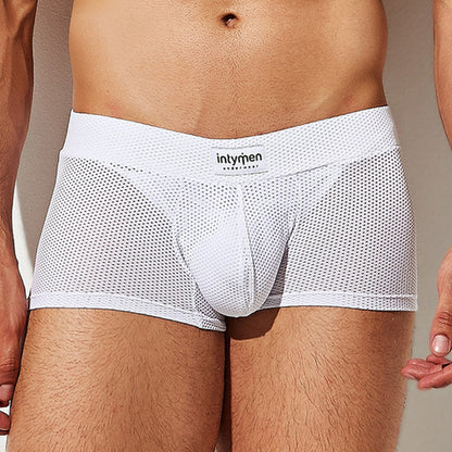 A person wearing Intymen Bulge Pouch Athletic Boxer briefs in white breathable mesh, showcasing a visible Intymen waistband. Designed for a snug fit and featuring a C-Shape Pouch for extra comfort, the focus is on the lower torso.