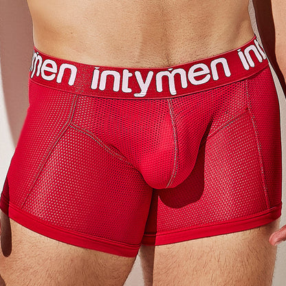 An individual sporting the Intymen ING081 Luxury Trunk Boxer, made from high-quality fabric in a vibrant red mesh style, with a white waistband displaying intymen and equipped with a contouring pouch for added support.