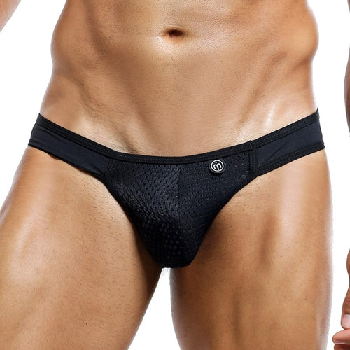 A person wearing Intymen Bikini briefs with a logo waistband is shown from the lower torso to upper thighs, highlighting the sleek mesh fabric and trendy high-cut design.