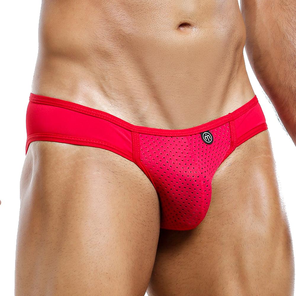 A person wearing the eye-catching Intymen Bikini in red mesh fabric. The image focuses on a close-up from waist to upper thighs, highlighting the fit and design of this stylish Intymen male bikini.