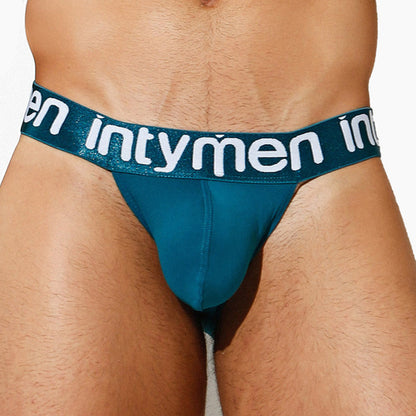Close-up of a person wearing Intymen Capri Bikini, showcasing its supportive pouch. The teal design with intymen on the waistband highlights style and comfort, while breathable fabric ensures ease from the front view and focuses on the elastic band.