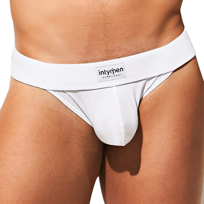 A person wears Intymen Fresh Bikini white briefs featuring the intymen label. The focus is on the premium fabric blend underwear against a plain background.