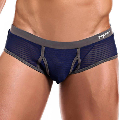 A male torso models the Intymen Profile Brief, revealing its dark blue and grey design. The sheer fabric adds allure, and the shaped support pouch ensures a fitted style.