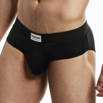 Wearing Intymen Femme Briefs, this person highlights the blend of style and comfort, with a visible Intymen label on the waistband. The plain background keeps the focus on the sleek underwear design.