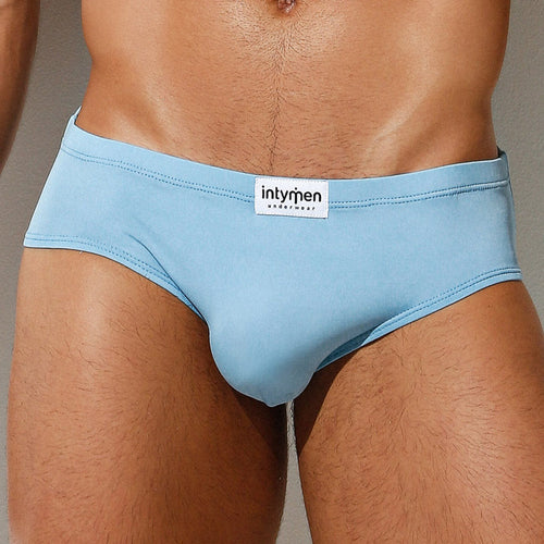 A person is depicted from waist to mid-thigh, sporting Intymen Amore Briefs in light blue, crafted with luxurious fabric and contoured pouch support.