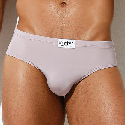 A close-up displays the Intymen Amore Brief, highlighting a waistband labeled intymen. The premium fabric and contoured pouch offer comfort and style, set against a neutral background that emphasizes its sleek design.