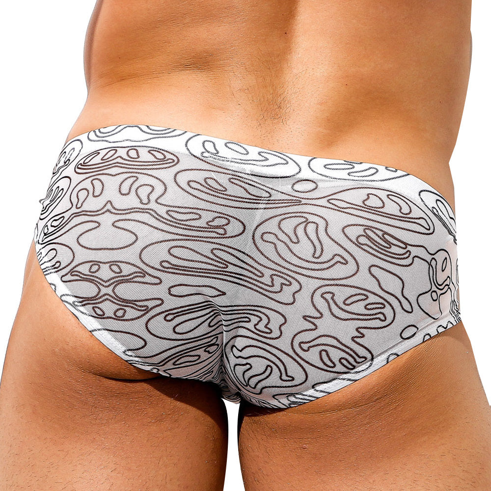 A person is shown from the lower back wearing Intymen Distortion Briefs by Intymen, featuring an abstract black design on white fabric with a high-cut leg, highlighting its eye-catching pattern.