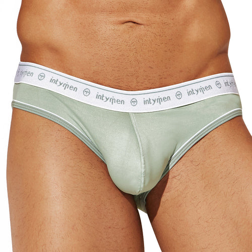 A person wears Intymen See Through Back Briefs in light green with a white waistband labeled intymen, revealing the midsection and upper thighs and highlighting the breathable cotton fabric.