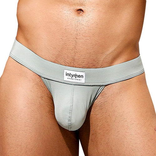 An individual is wearing an Intymen Sensual Thong in sleek, light gray with a visible brand label on the waistband. The image emphasizes the waist and hips, showcasing its comfortable fit.