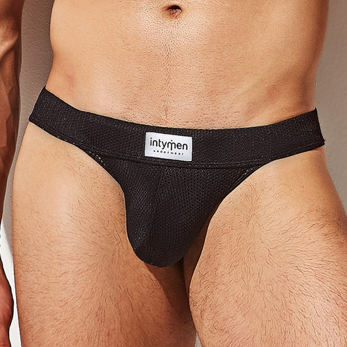 The Intymen Mesh Seductive Thong showcases sporty style with its breathable mesh fabric and a prominent intymen waistband label. Its V-shape design stands out against a simple background, adding a sleek touch to your attire.