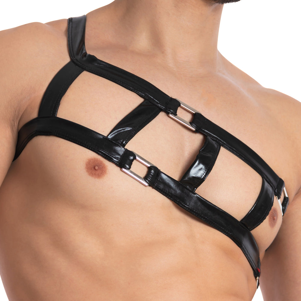 Shirtless and confident, a person wearing the Miami Jock Accessory Harness features bold black leather straps with metal rings across their chest, showcasing an intriguing geometric pattern and embodying stylish sexiness.