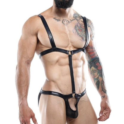 A tattooed, muscular individual confidently models the Miami Jock Bodysuit against a white background. This sexy apparel by Miami Jock features minimal coverage with black leather straps over the shoulders and body, capturing the brands signature allure.