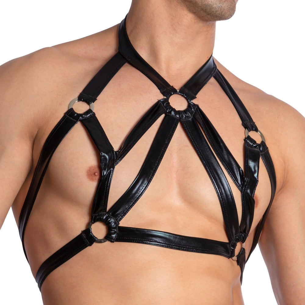 A person wearing the Miami Jock Ring Harness, crafted from premium fabric featuring a five-ring design with multiple straps connecting over their chest to create a bold and structured look.