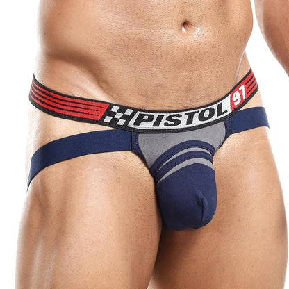 Someone is wearing a Pistol Pete Jockstrap in blue and gray, featuring a wide red-and-black striped waistband with PISTOL and 97 text. The design showcases premium fabric with side cutouts and a supportive front pouch.