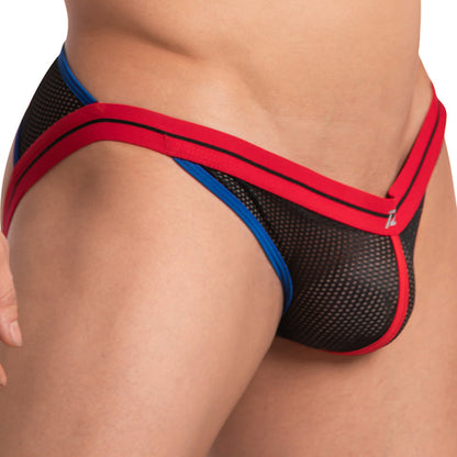 Close-up of a person wearing a black mesh Pistol Pete Pistol Pecker Jockstrap with red and blue trim, focusing on the waist and hip area to highlight the supportive pouch that showcases its design and texture.