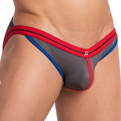 A close-up shows someone wearing the Pistol Pete Pistol Pecker Jockstrap, a sporty gray mesh design with red and blue trim, featuring a supportive pouch and double top bands for style and comfort.