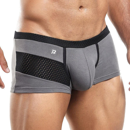 The model showcases Pistol Pete Boxer Trunk in gray and black with mesh panels, featuring a unique black waistband. Ideal for athletic wear, the supportive pouch ensures comfort and fit, highlighting the style when worn by revealing torso and legs.